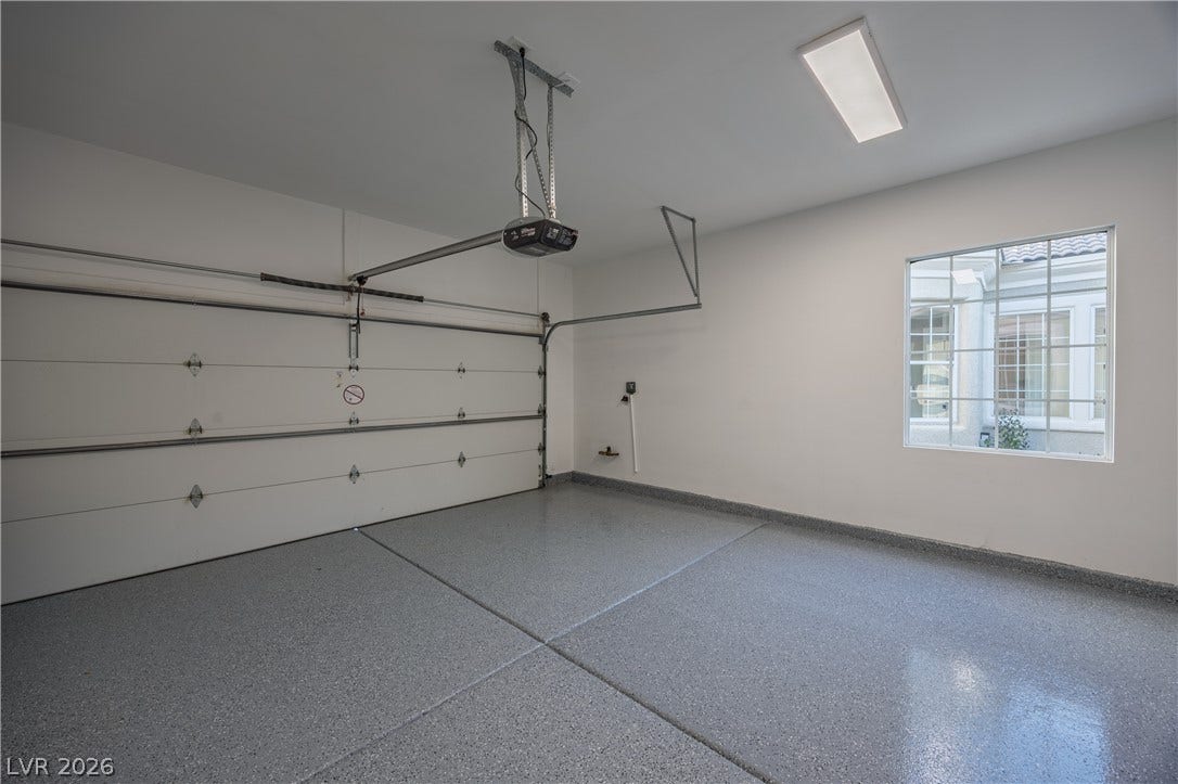 10248 Andante Court, Las Vegas, NV 89135 Garage featuring baseboards and a garage door opener