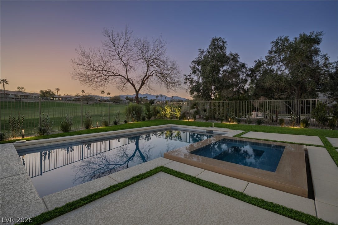 10248 Andante Court, Las Vegas, NV 89135 Pool at dusk with a fenced backyard, a patio, and a pool with connected hot tub