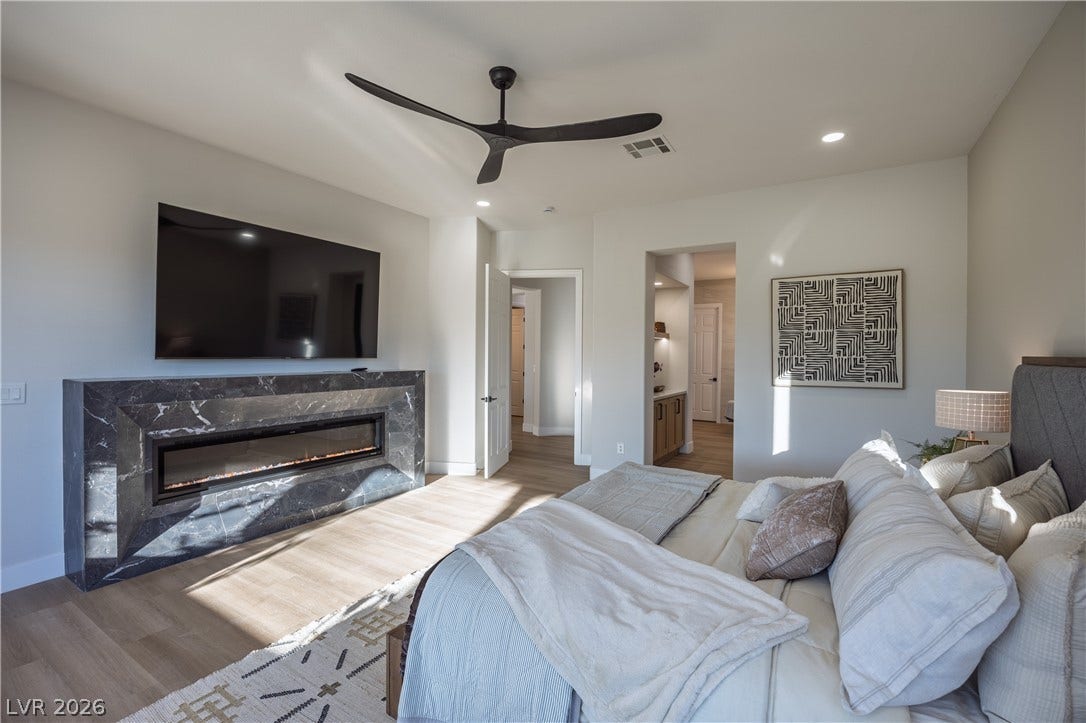 10248 Andante Court, Las Vegas, NV 89135 Bedroom with wood finished floors, a premium fireplace, a ceiling fan, recessed lighting, and ensuite bathroom