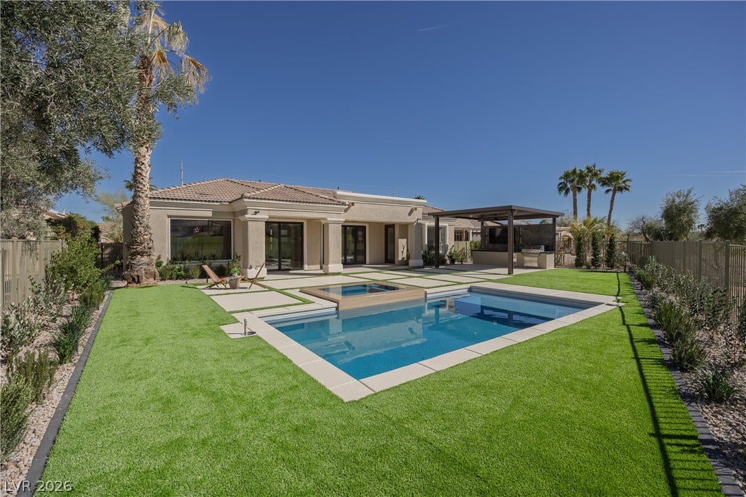 10248 Andante Court, Las Vegas, NV 89135 Back of house featuring a fenced backyard, a patio, stucco siding, a pool with connected hot tub, and a tiled roof