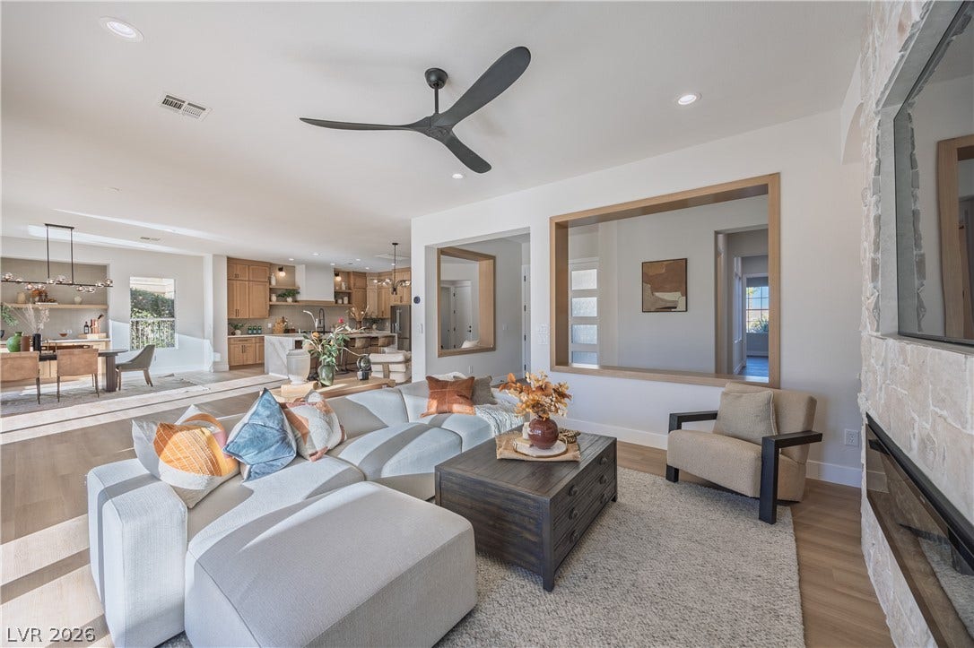 10248 Andante Court, Las Vegas, NV 89135 Living room featuring light wood finished floors, ceiling fan, recessed lighting, and a stone fireplace