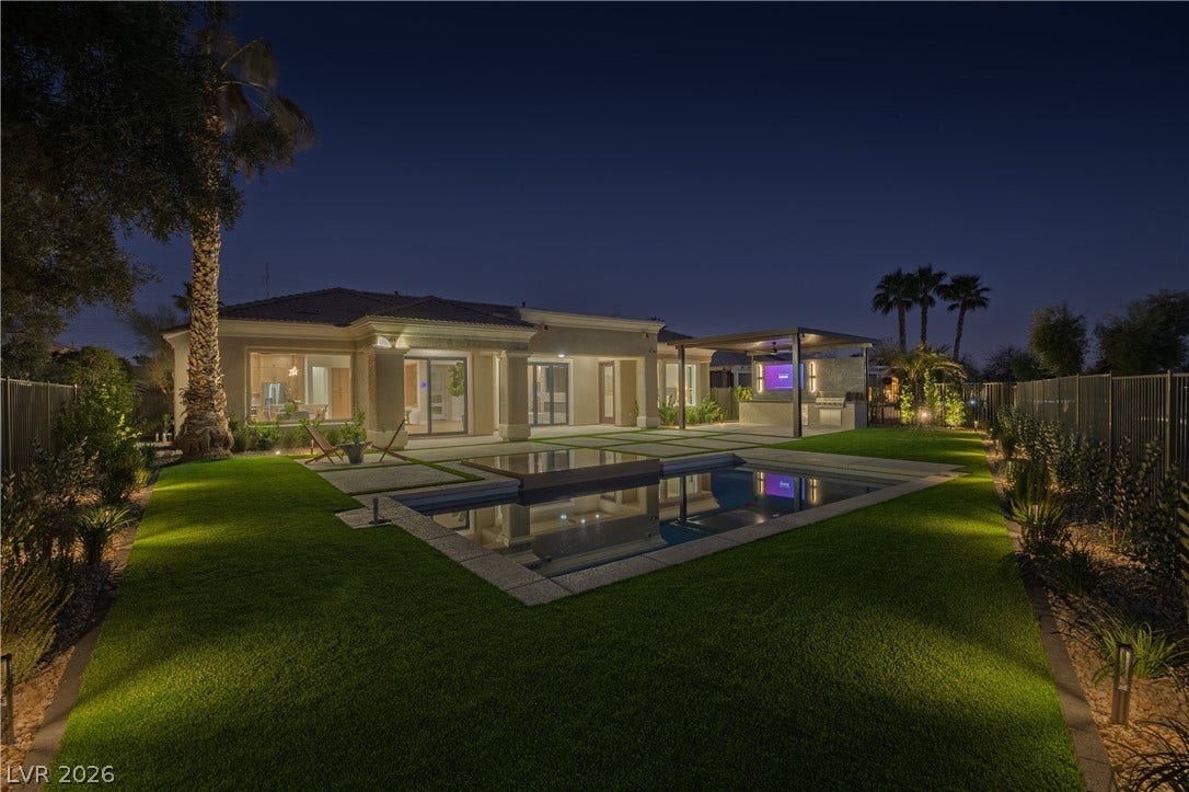 10248 Andante Court, Las Vegas, NV 89135 Back of house at twilight with a fenced backyard, a patio area, a pool with connected hot tub, and stucco siding