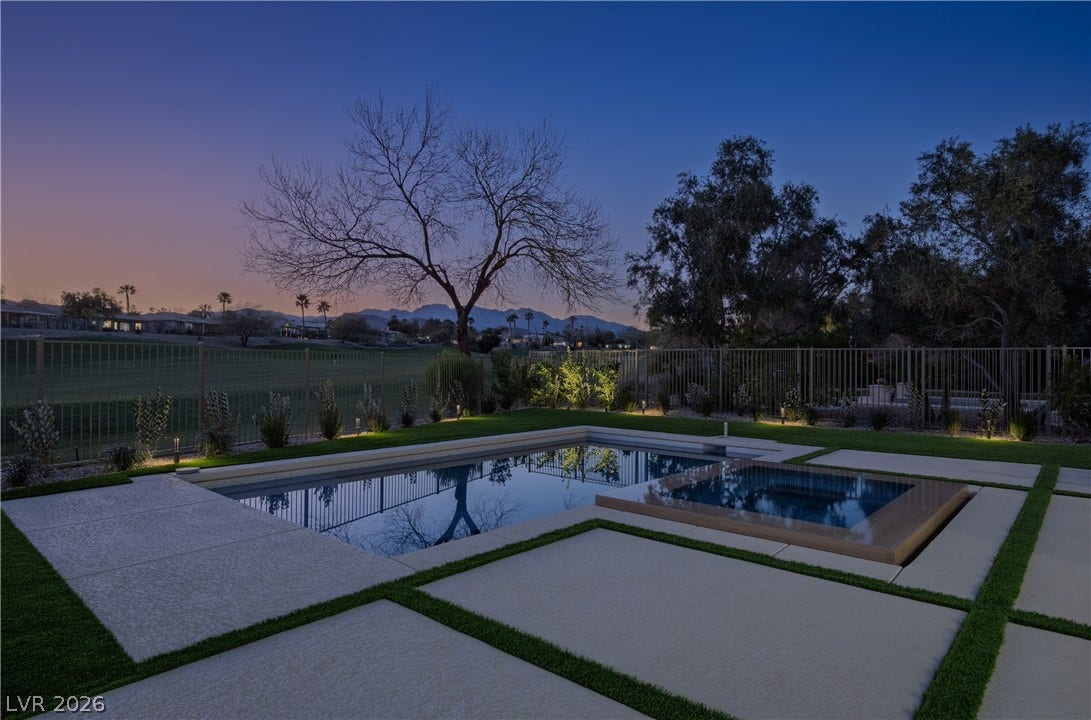 10248 Andante Court, Las Vegas, NV 89135 Pool at dusk featuring a fenced backyard, a patio, a mountain view, and a pool with connected hot tub