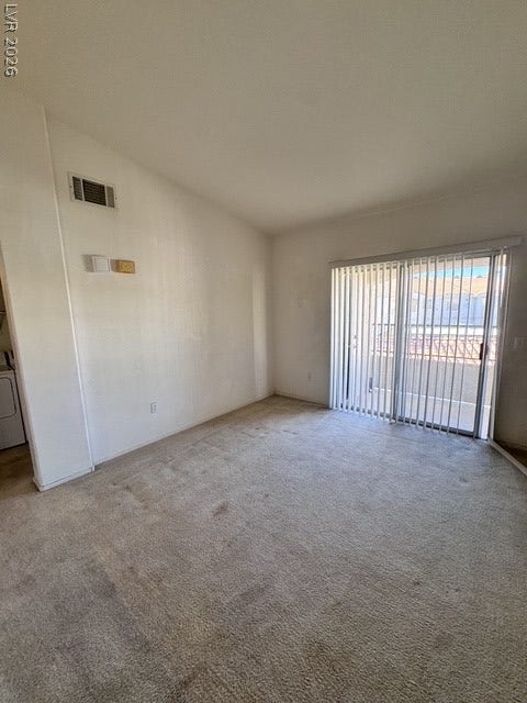 1881 W Alexander Road, #2107, North Las Vegas, NV 89032 Plentiful natural light streams through wide sliding glass doors onto wall-to-wall carpeting.