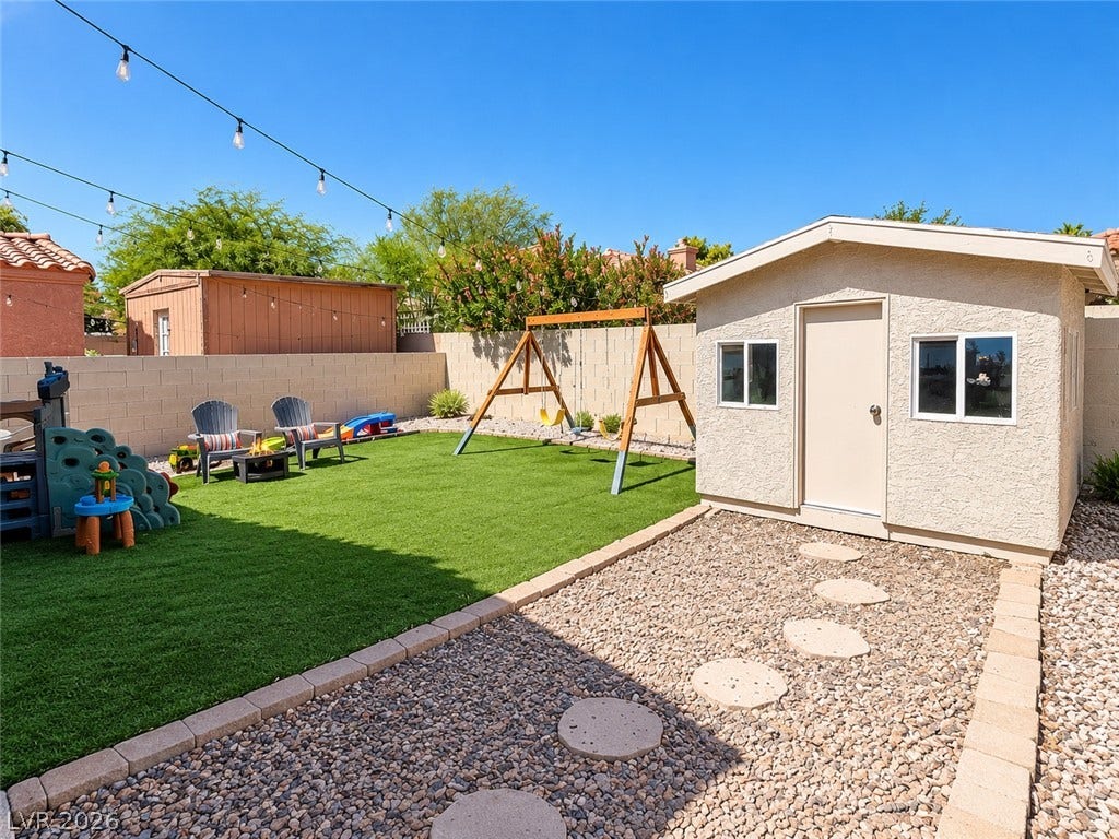 4927 Rancho Domingo Court, North Las Vegas, NV 89031 An inviting backyard features low-maintenance synthetic turf alongside a practical detached storage shed.