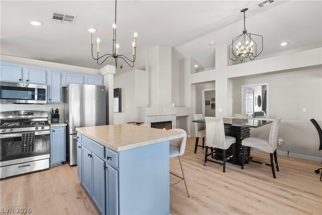 4927 Rancho Domingo Court, North Las Vegas, NV 89031 Hardwood floors and high ceilings elevate this open kitchen and dining area with fireplace.