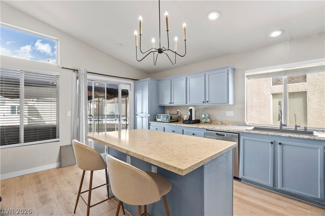 4927 Rancho Domingo Court, North Las Vegas, NV 89031 A spacious cooking area integrates durable stone counters and a central island workspace under vaulted ceilings.