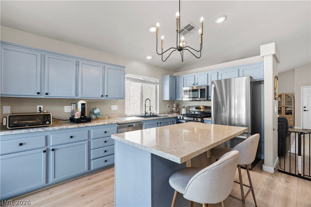 4927 Rancho Domingo Court, North Las Vegas, NV 89031 An inviting kitchen centers around a spacious stone island and smooth hardwood floors.