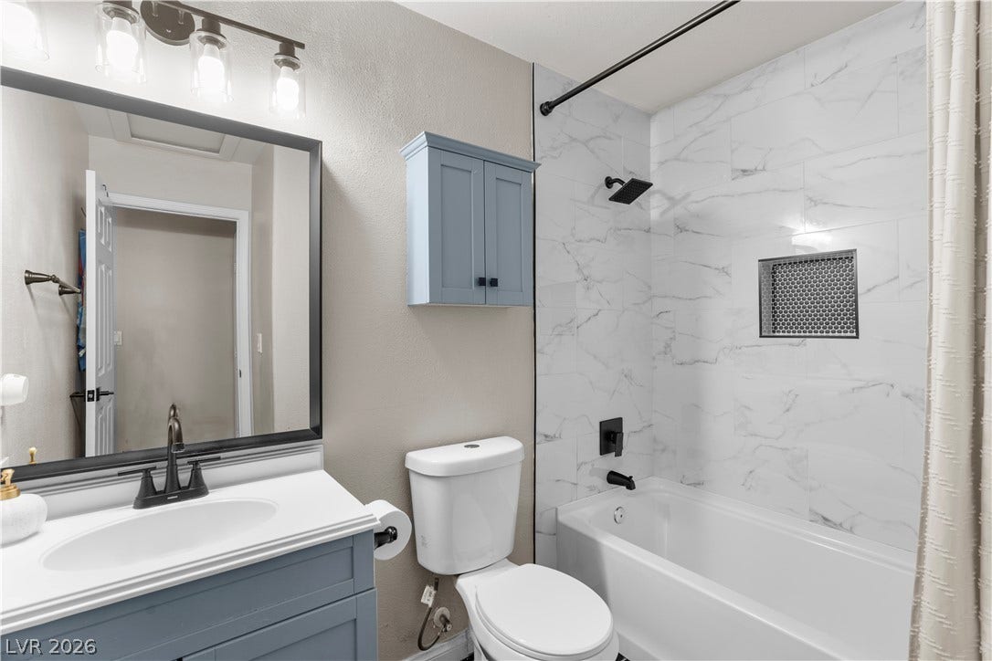 4927 Rancho Domingo Court, North Las Vegas, NV 89031 Marble-patterned wall tile wraps the bathtub area in this updated bathroom.