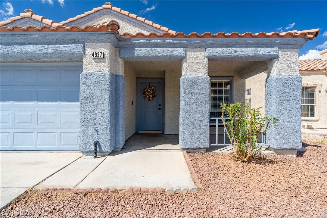 4927 Rancho Domingo Court, North Las Vegas, NV 89031 Clay roof tiles and stucco pillars framing a welcoming covered front porch entry.