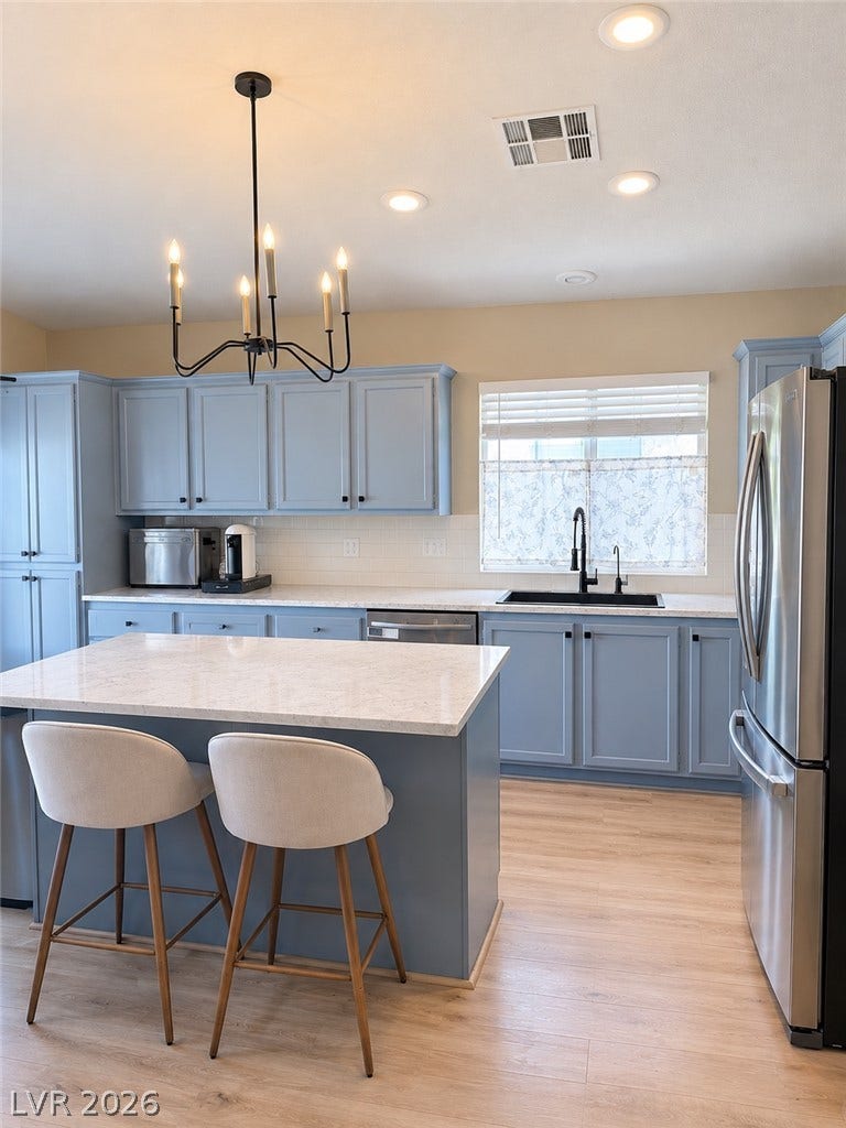 4927 Rancho Domingo Court, North Las Vegas, NV 89031 An open kitchen layout features clean lines, classic cabinetry, and durable stone countertops.