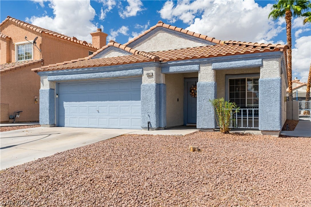4927 Rancho Domingo Court, North Las Vegas, NV 89031 A classic Spanish tile roof and two-car garage define this stucco home's exterior.