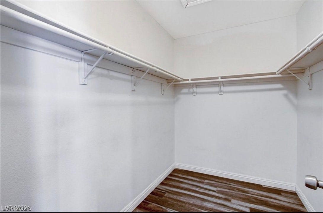 2514 Inlet Spring Avenue, North Las Vegas, NV 89031 Ample hanging rods and shelving wrap around this walk-in closet with durable wood-look flooring.