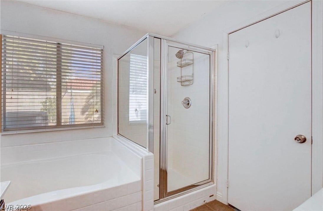 2514 Inlet Spring Avenue, North Las Vegas, NV 89031 A glass-enclosed walk-in shower sits adjacent to a deep soaking tub.