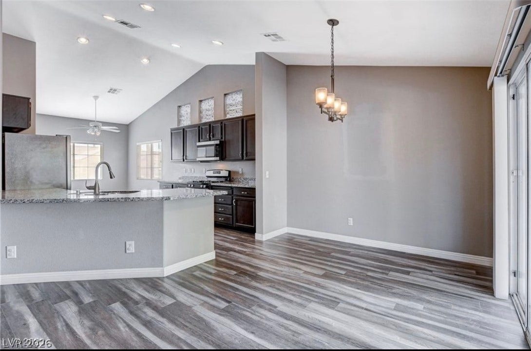2514 Inlet Spring Avenue, North Las Vegas, NV 89031 Plank flooring and vaulted ceilings design this open interior dining and kitchen layout.