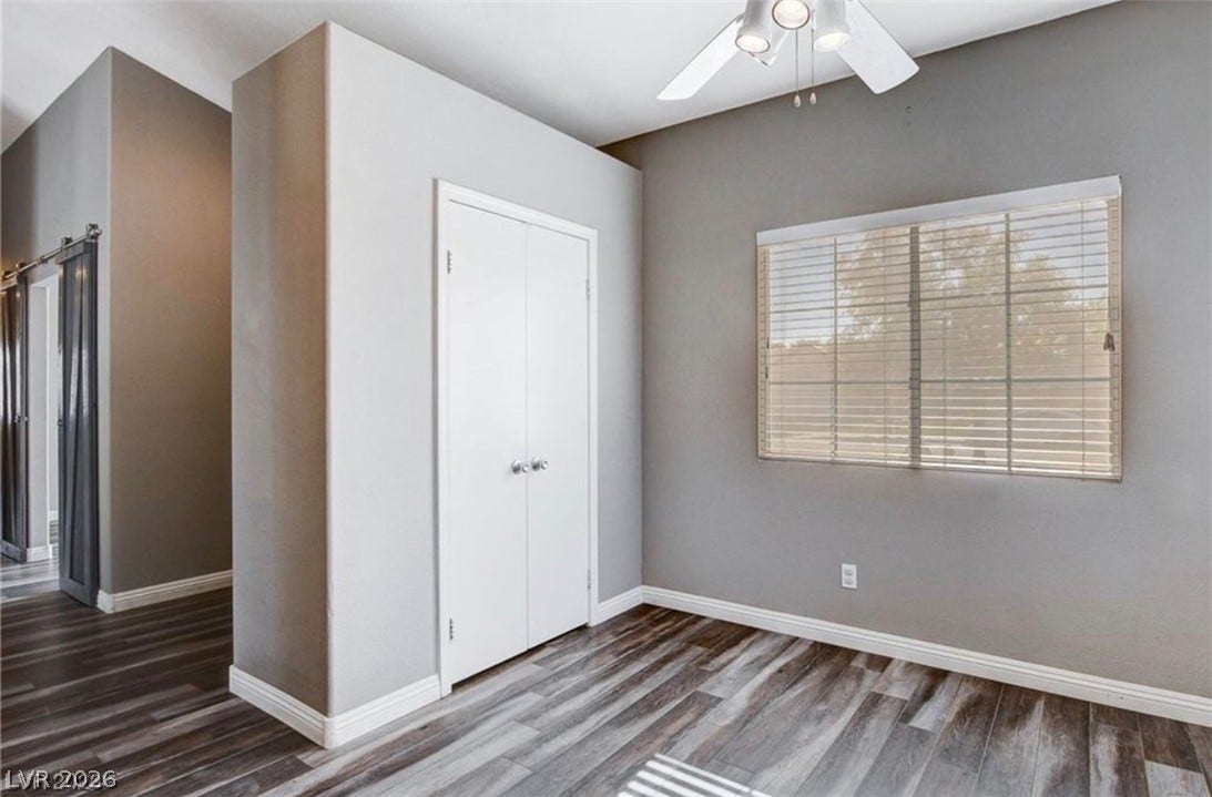 2514 Inlet Spring Avenue, North Las Vegas, NV 89031 Rich wood-inspired flooring and a wide window with integrated blinds highlight this versatile space.