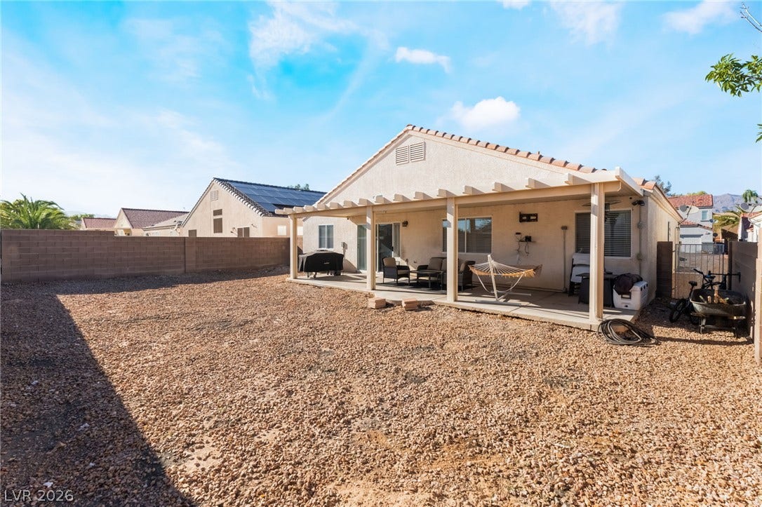 3729 Shimmering Creek Avenue, North Las Vegas, NV 89031 A spacious gravel yard extends from a covered concrete patio under clear desert skies.