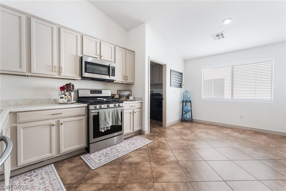 3729 Shimmering Creek Avenue, North Las Vegas, NV 89031 Tiled flooring and matching cabinetry complement the adjacent dining space under a vaulted ceiling.