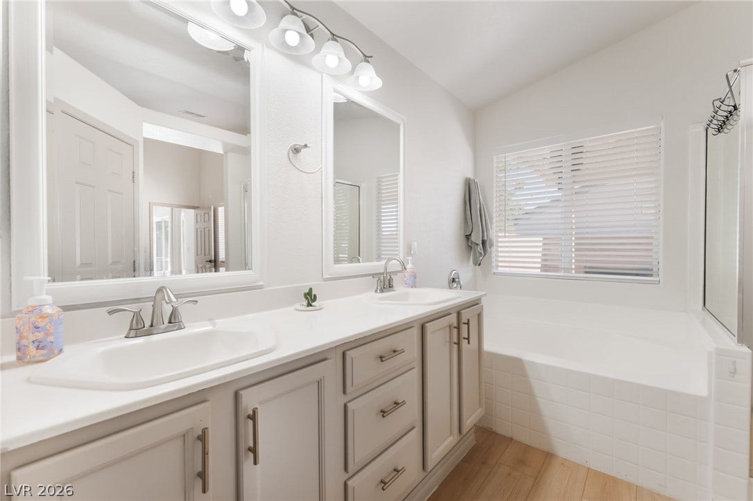 3729 Shimmering Creek Avenue, North Las Vegas, NV 89031 Clean lines and a spacious dual vanity highlight this primary bathroom featuring a soaking tub.