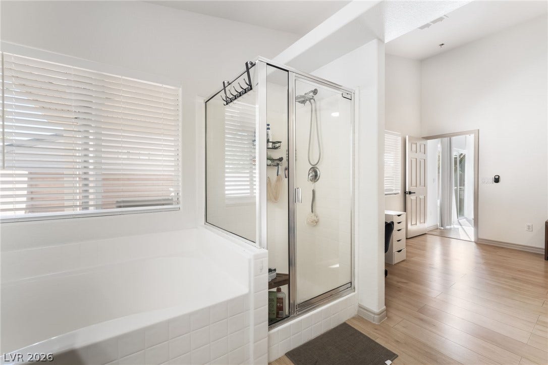 3729 Shimmering Creek Avenue, North Las Vegas, NV 89031 High ceilings and clean tiled finishes define this main bathroom retreat with a separate tub.