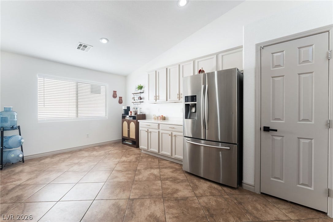 3729 Shimmering Creek Avenue, North Las Vegas, NV 89031 Tiled flooring and recessed lighting complement the built-in cabinetry and stainless steel refrigerator.