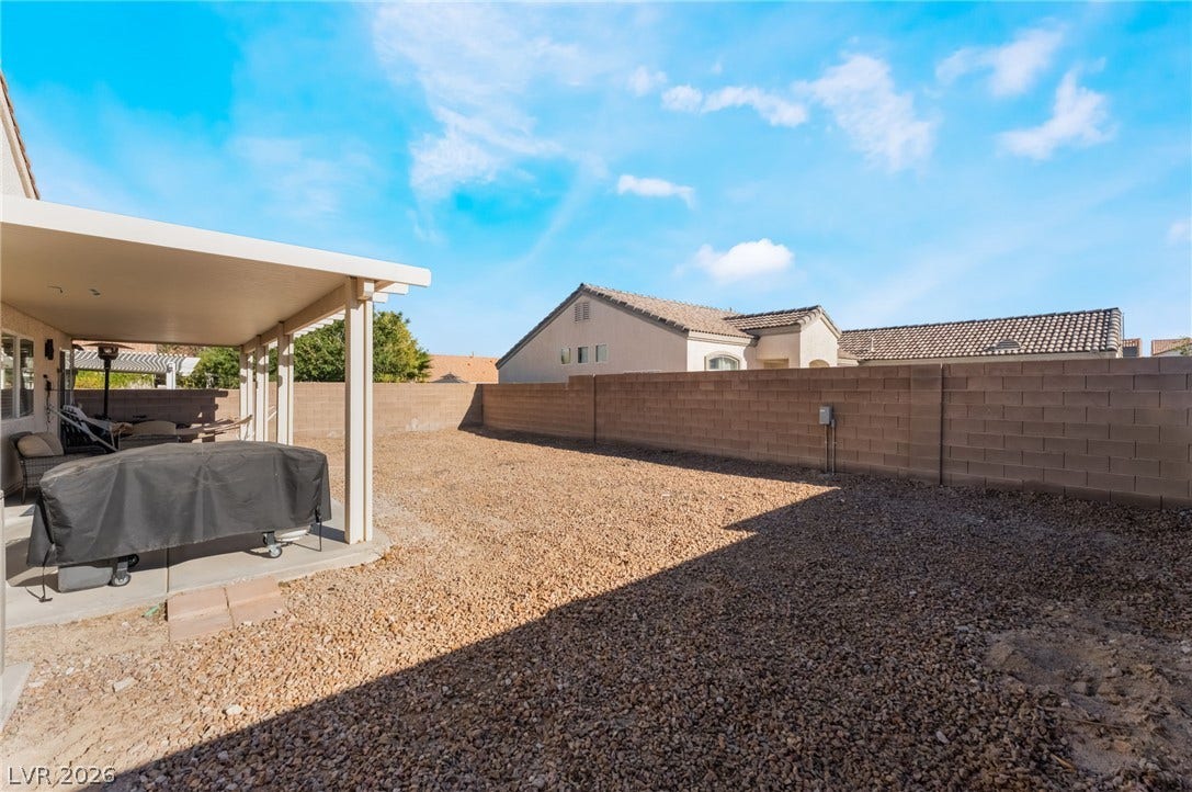 3729 Shimmering Creek Avenue, North Las Vegas, NV 89031 An enclosed backyard features low-maintenance gravel landscaping and a covered concrete patio.