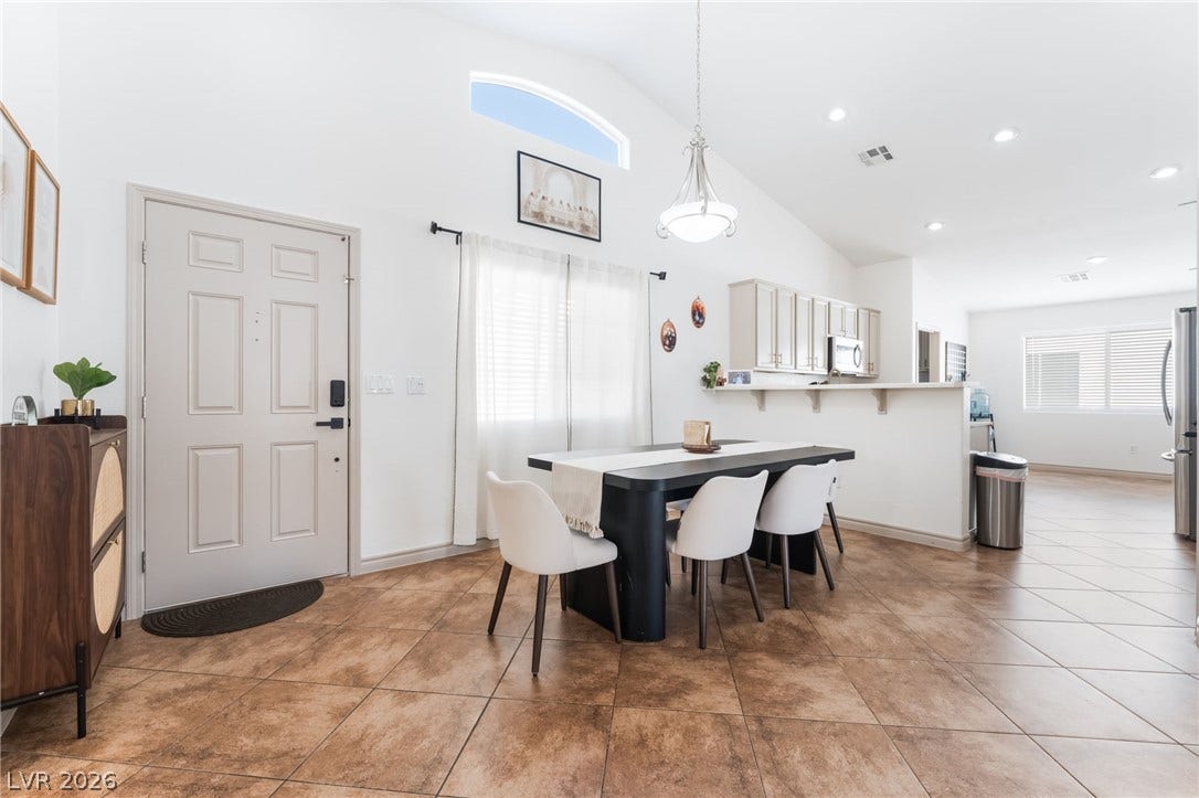 3729 Shimmering Creek Avenue, North Las Vegas, NV 89031 Soaring vaulted ceilings and durable tile flooring define this airy open-concept dining space.