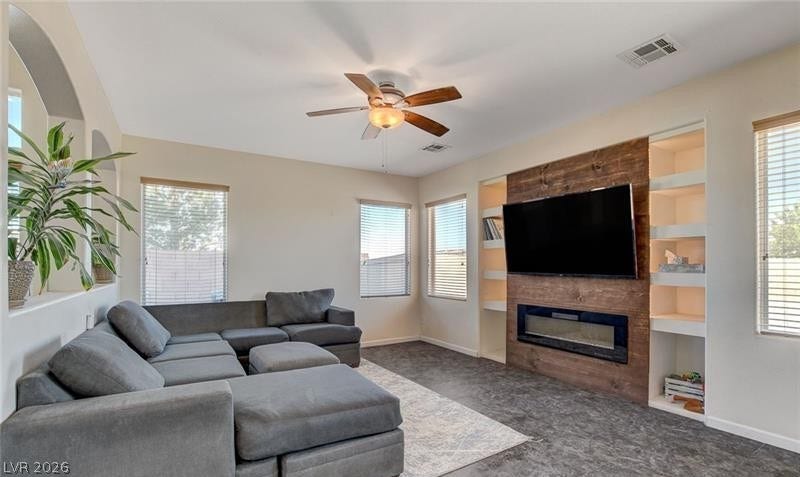 4 Goldleaf Falls Avenue, North Las Vegas, NV 89031 A wood-paneled fireplace surround with integrated shelving anchors this comfortable main living space.