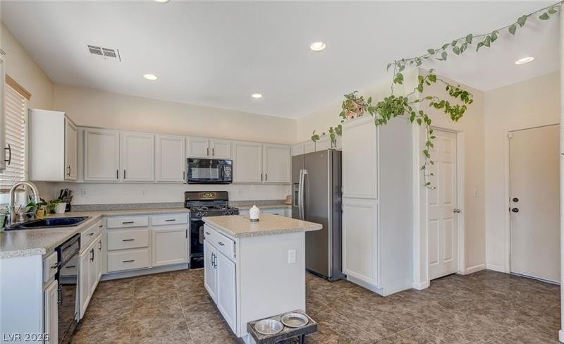4 Goldleaf Falls Avenue, North Las Vegas, NV 89031 A spacious kitchen highlights stone countertops, matching cabinetry, and durable tile flooring.