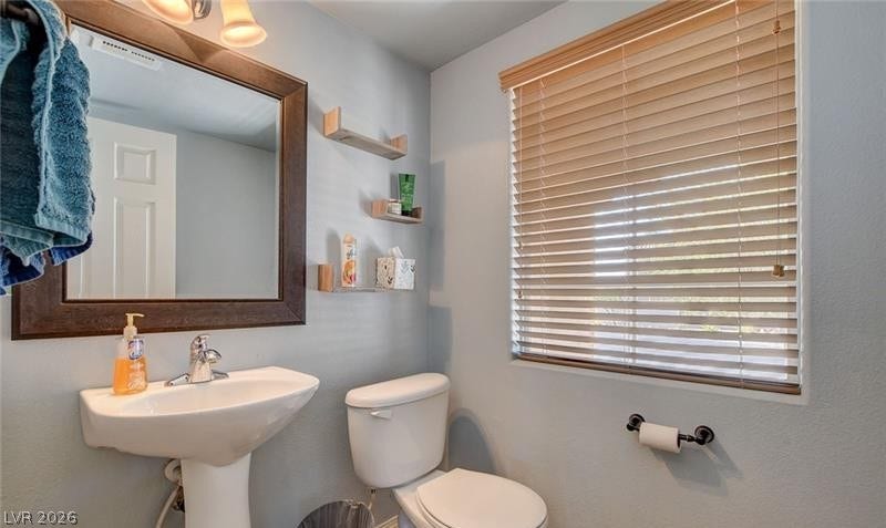 4 Goldleaf Falls Avenue, North Las Vegas, NV 89031 A pedestal sink and framed mirror accent this cozy, functional washroom.