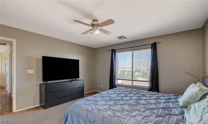 4 Goldleaf Falls Avenue, North Las Vegas, NV 89031 Natural light streams through a large window, highlighting the carpeted floor and smooth walls.