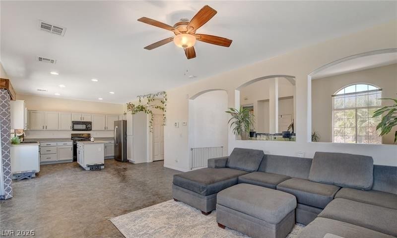 4 Goldleaf Falls Avenue, North Las Vegas, NV 89031 An open floor plan connects the living area to a spacious kitchen with concrete floors.
