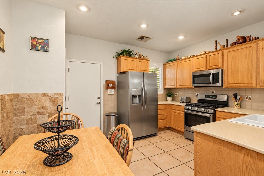 Warm oak cabinetry pairs beautifully with tile floors in this spacious culinary workspace.