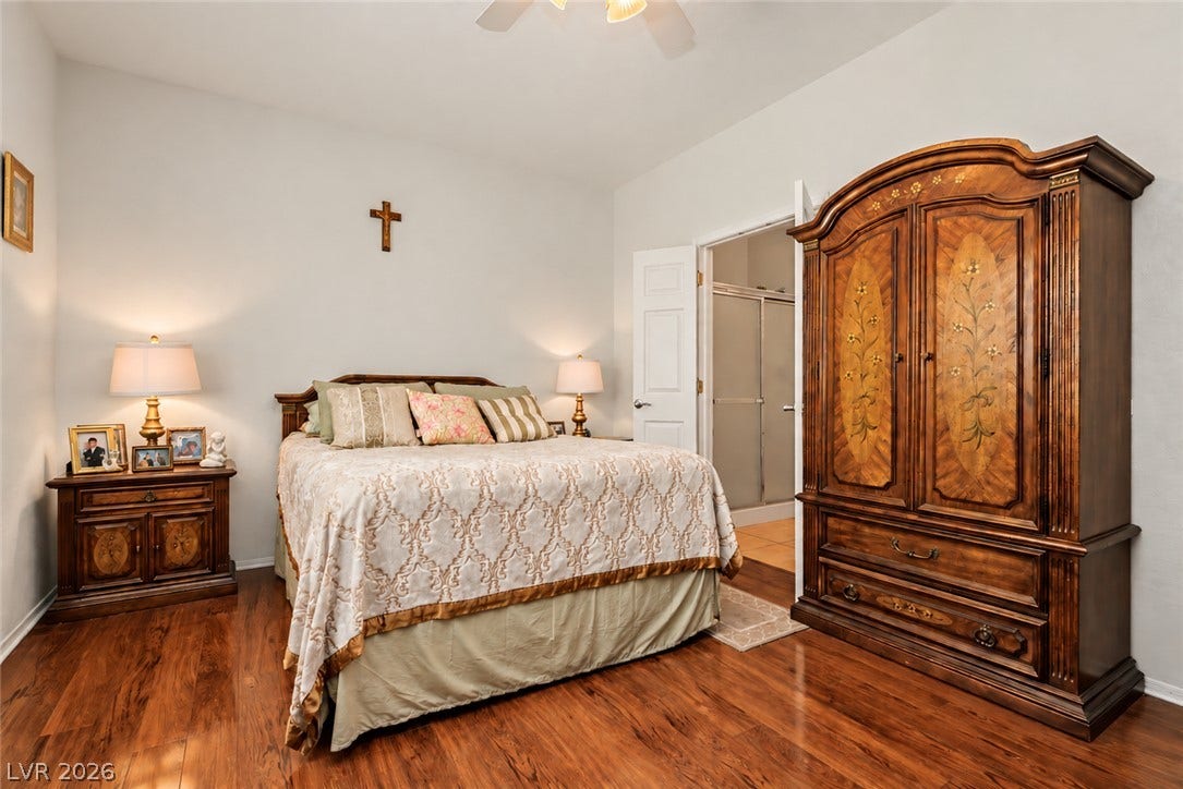 Rich hardwood flooring anchors this inviting bedroom leading to an en suite bath.