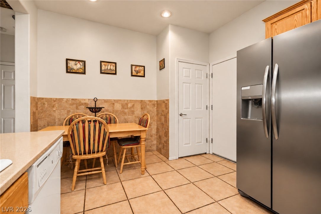 Tiled flooring and recessed lighting define this inviting dining area adjacent to the kitchen.