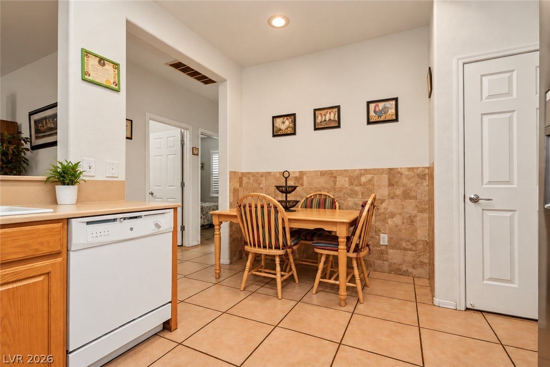 Warm tile flooring runs throughout this charming dining space adjacent to the kitchen.