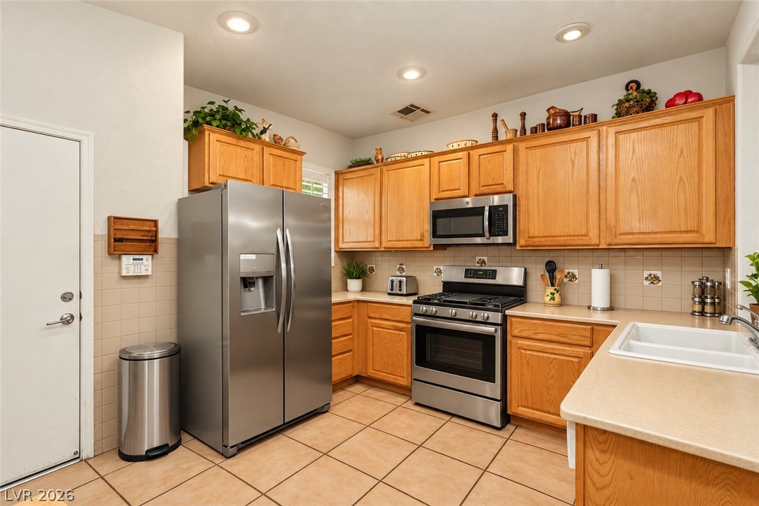 Warm oak cabinetry pairs with durable tile flooring in this classic kitchen design.