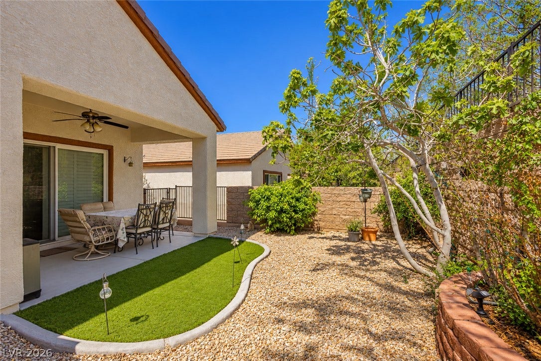 A covered concrete patio transitions into a low-maintenance gravel yard with a neat putting green.