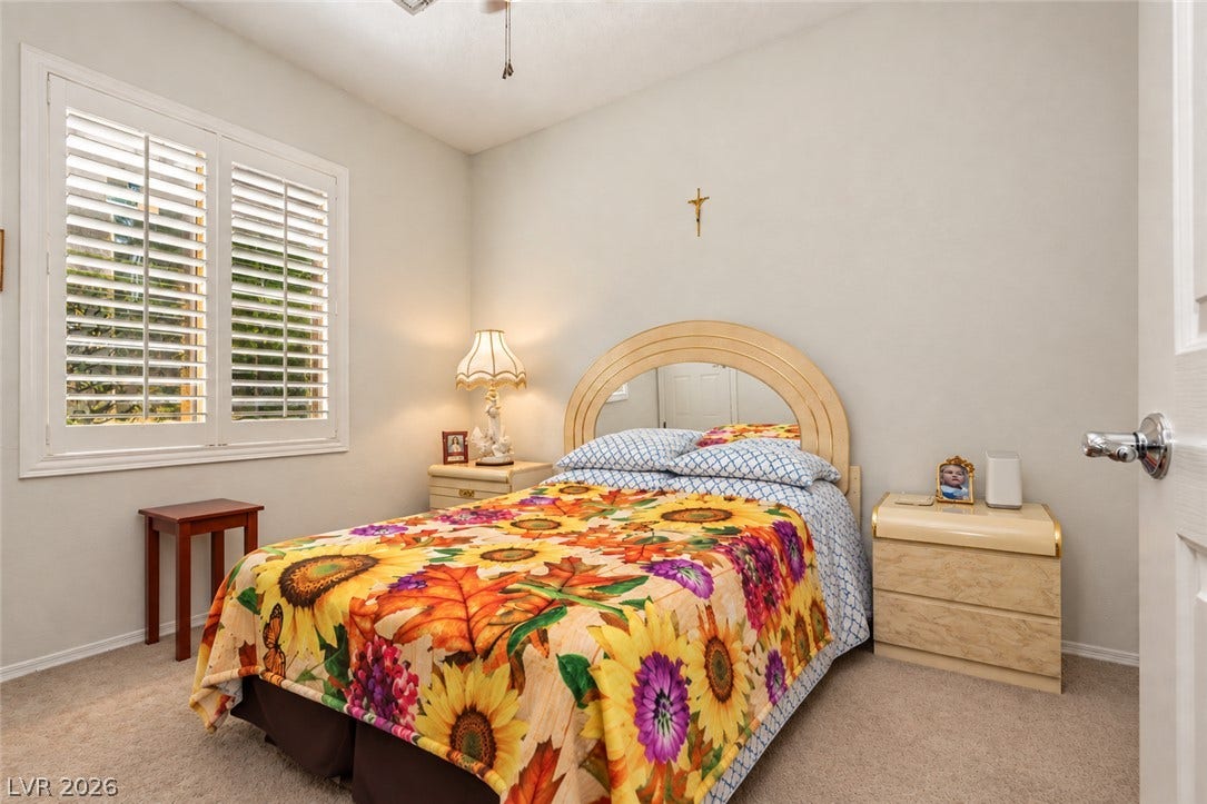 An arched alcove mirror and classic plantation shutters enhance this cozy bedroom retreat.