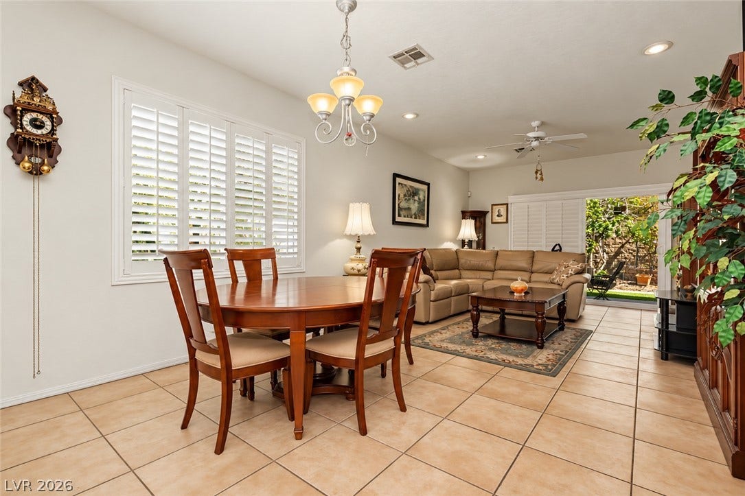 An open-concept living and dining layout features classic tile flooring and abundant natural light.