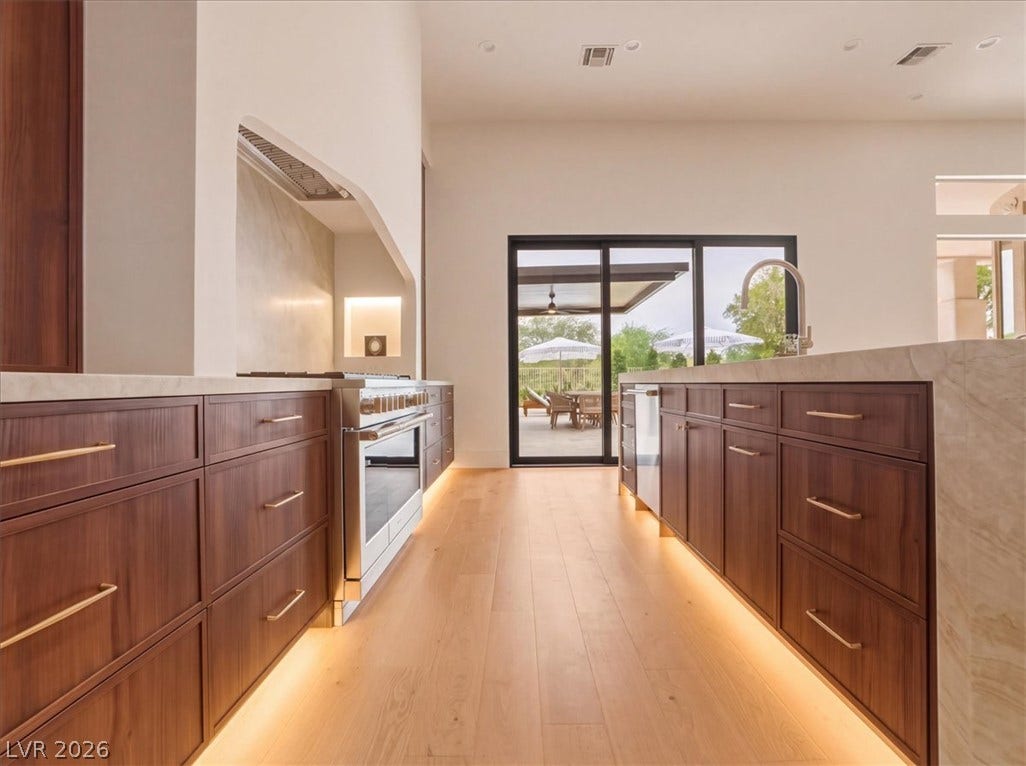 3 Isleworth Drive, Henderson, NV 89052 Culinary excellence awaits in this kitchen, boasting a sleek range, elegant cabinetry, and seamless outdoor access.