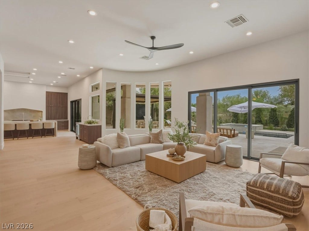 3 Isleworth Drive, Henderson, NV 89052 Natural light floods this living area, featuring light wood floors and seamless access to the outdoor oasis.