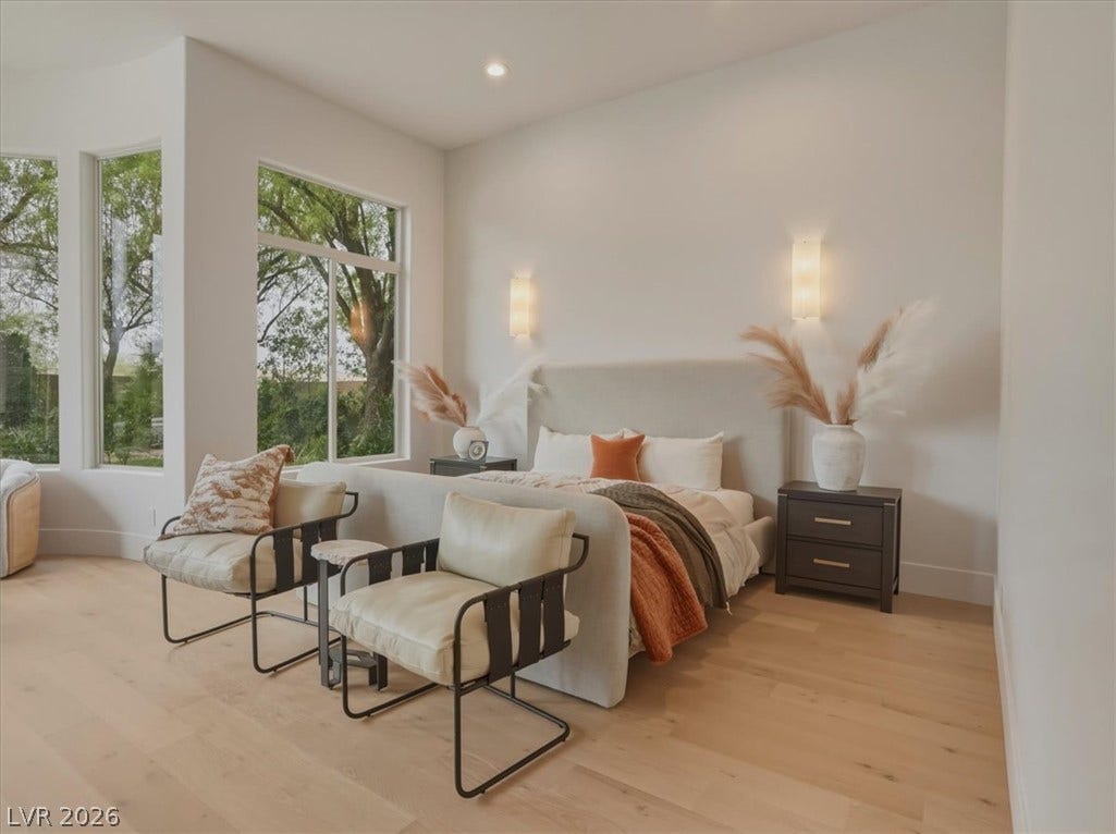 3 Isleworth Drive, Henderson, NV 89052 Ample natural light illuminates a tranquil bedroom retreat with warm wood flooring and verdant views.