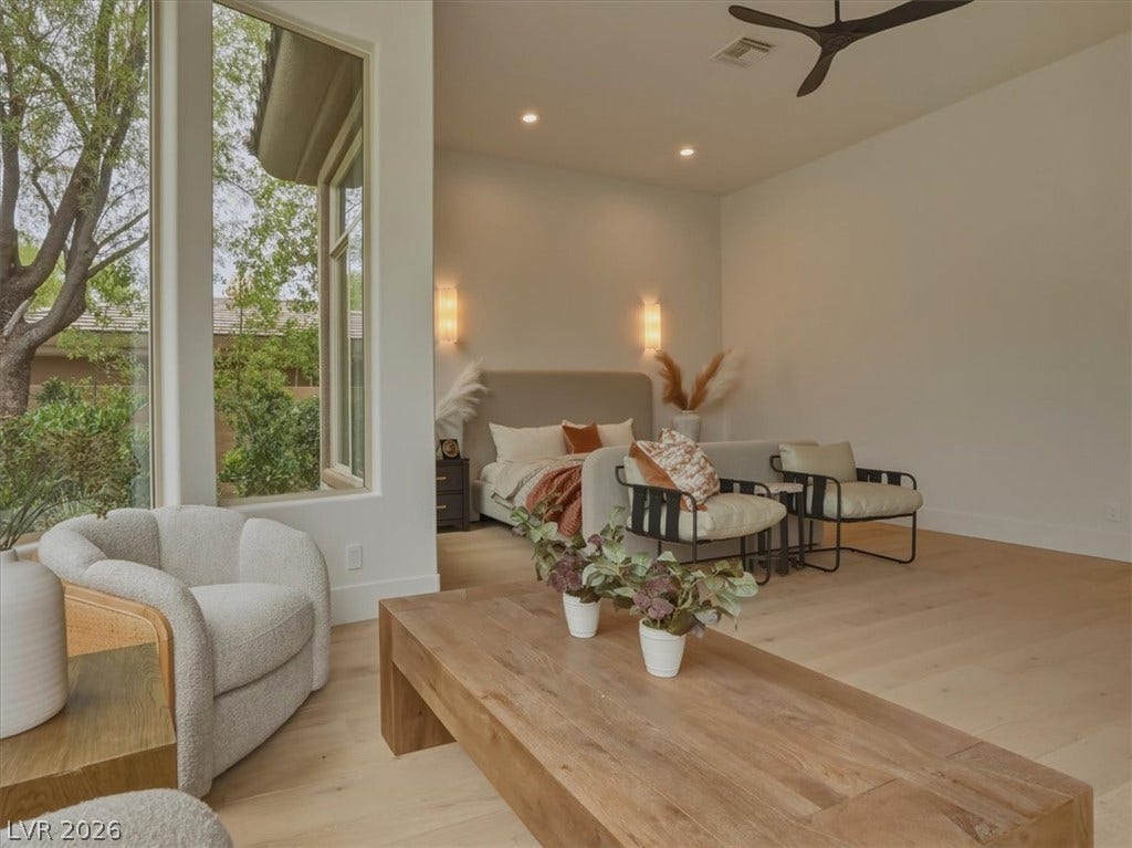 3 Isleworth Drive, Henderson, NV 89052 Natural light floods this inviting primary suite, featuring elegant hardwood flooring and a statement ceiling fan.