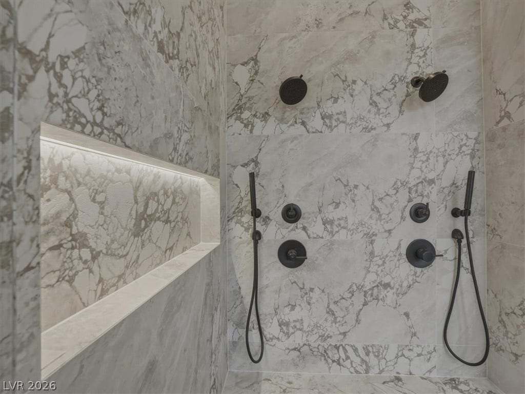 3 Isleworth Drive, Henderson, NV 89052 Luxurious marble tiling creates a refined and practical shower space with multiple shower heads and a lighted alcove.