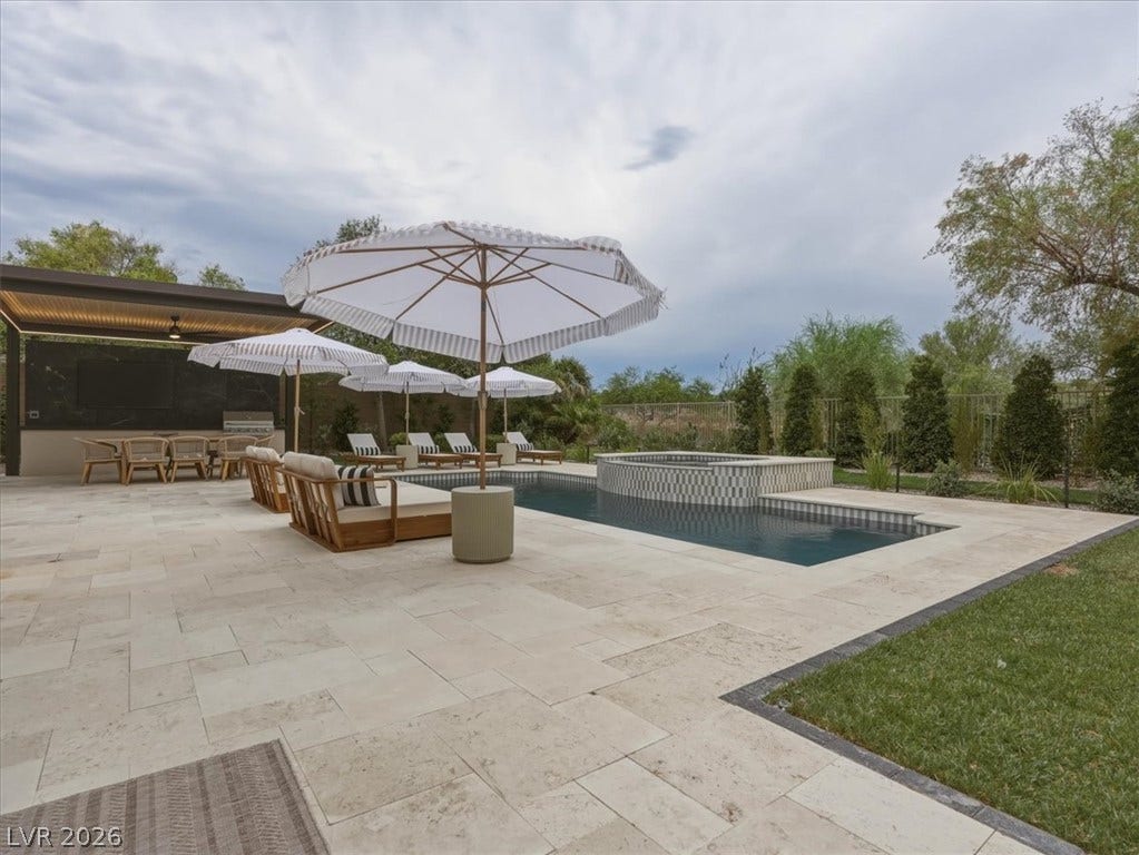 3 Isleworth Drive, Henderson, NV 89052 An inviting backyard oasis offers a sparkling pool and spa alongside a covered outdoor kitchen and dining area.