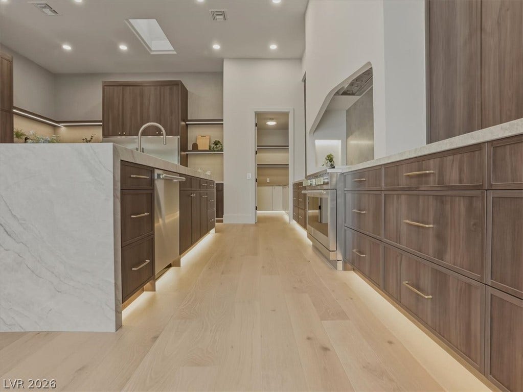 3 Isleworth Drive, Henderson, NV 89052 An immaculate culinary space features bright recessed lighting and a full suite of stainless steel appliances.