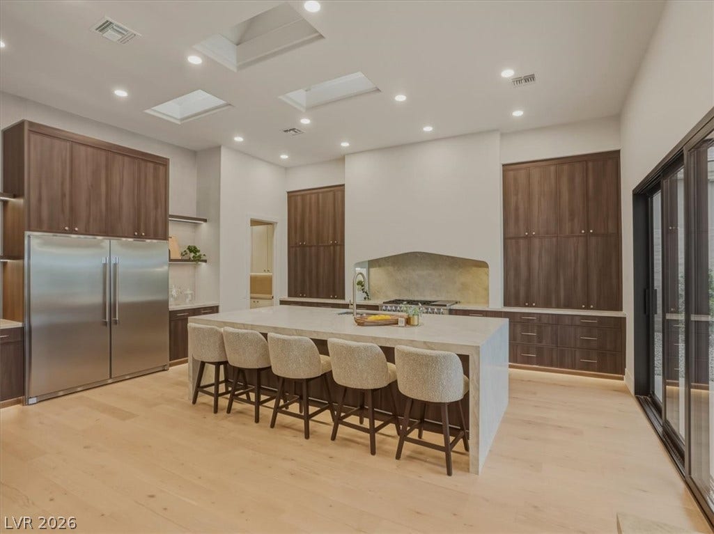 3 Isleworth Drive, Henderson, NV 89052 A well-lit kitchen with a spacious island, integrated appliances, and extensive cabinetry for seamless entertaining.