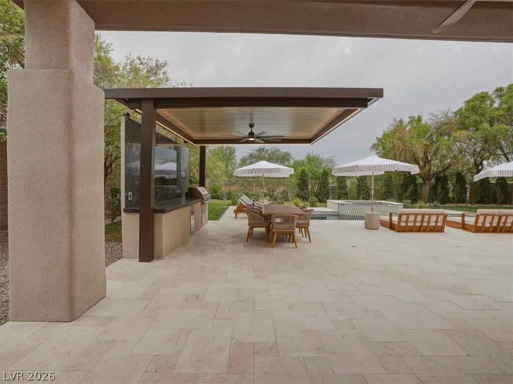 3 Isleworth Drive, Henderson, NV 89052 An inviting outdoor kitchen and dining area flows seamlessly onto a spacious patio, ideal for alfresco entertaining.