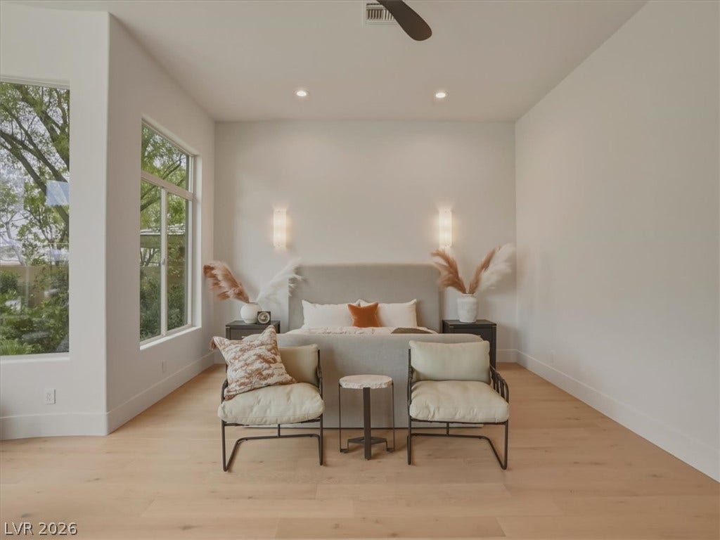3 Isleworth Drive, Henderson, NV 89052 A tranquil bedroom space features light wood flooring and well-lit walls, creating an airy retreat.